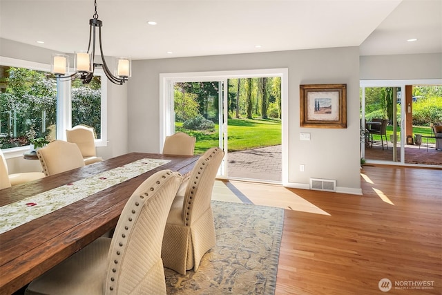 dining space with wood finished floors, plenty of natural light, a chandelier, recessed lighting, and baseboards