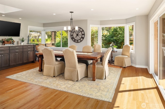 dining space with healthy amount of natural light, light wood-style floors, a chandelier, recessed lighting, and baseboards