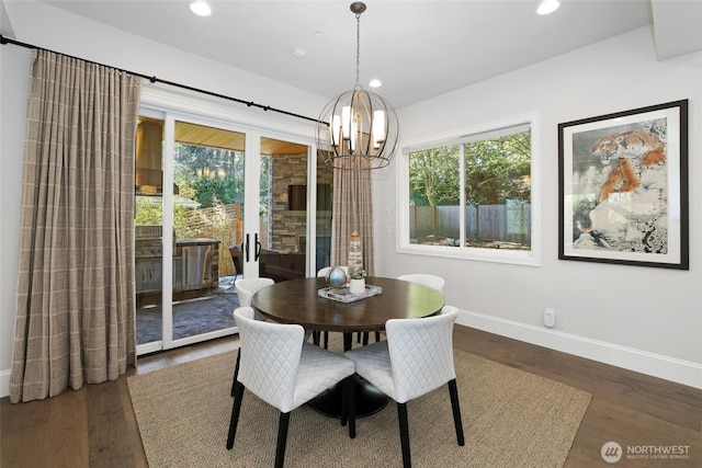 dining space featuring recessed lighting, baseboards, a notable chandelier, and wood finished floors