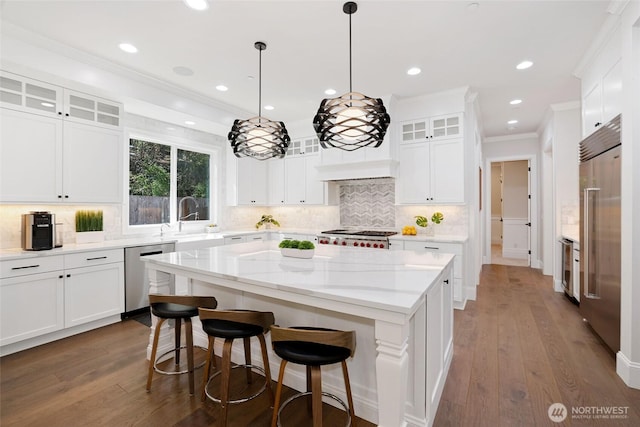 kitchen with a center island, a sink, appliances with stainless steel finishes, and white cabinets