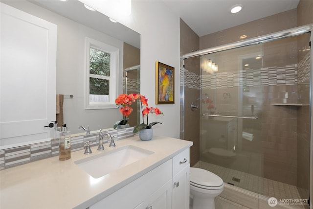 full bath featuring recessed lighting, vanity, a shower stall, and toilet
