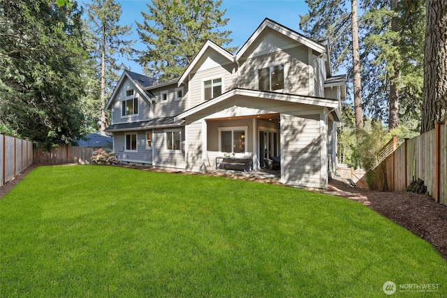 back of house with a lawn and a fenced backyard