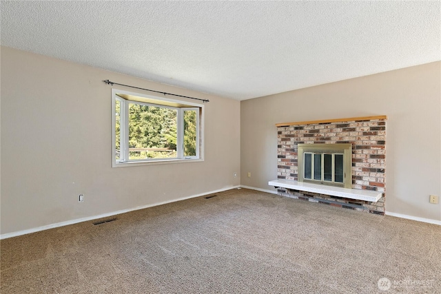 unfurnished living room featuring carpet floors, a textured ceiling, baseboards, and a brick fireplace