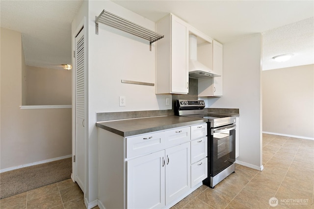 kitchen featuring stainless steel electric stove, wall chimney exhaust hood, dark countertops, and white cabinetry