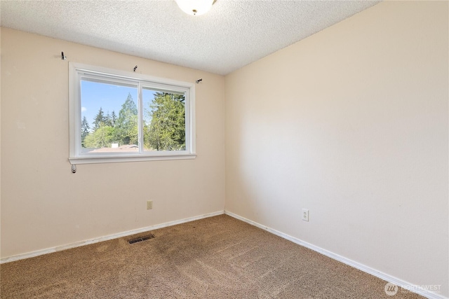 carpeted empty room with a textured ceiling and baseboards