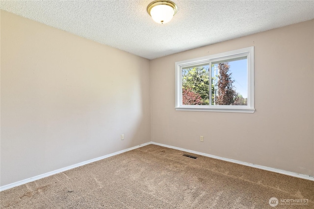 carpeted empty room with baseboards and a textured ceiling