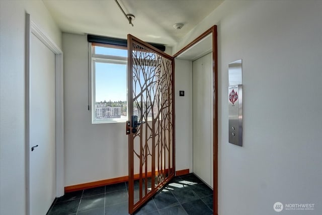 1 N Stadium Way Unit 16, Tacoma, WA 98403 - entrance foyer with elevator, dark tile patterned floors, and baseboards