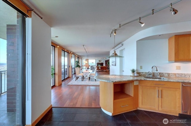 1 N Stadium Way Unit 16, Tacoma, WA 98403 - kitchen with a sink, dark tile patterned floors, open floor plan, light brown cabinetry, and light stone countertops