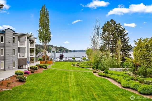 view of yard with fence, a patio, and a water view