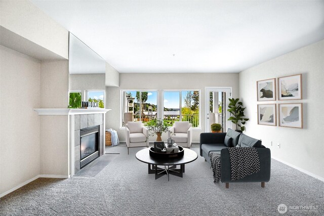 living area featuring baseboards, carpet flooring, and a tile fireplace