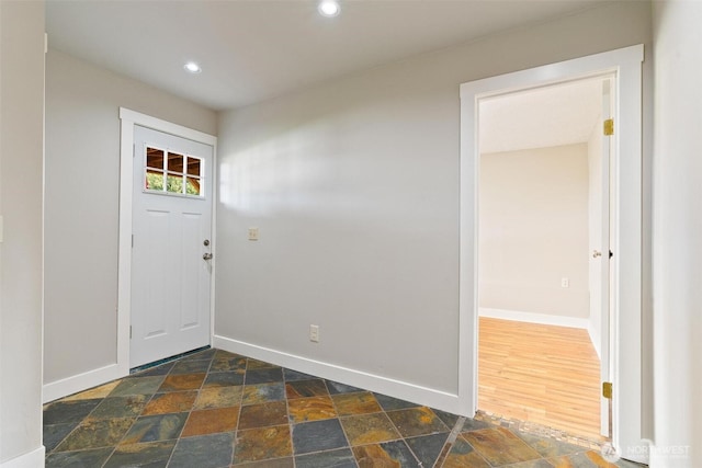 entrance foyer with baseboards, recessed lighting, and dark stone finish flooring