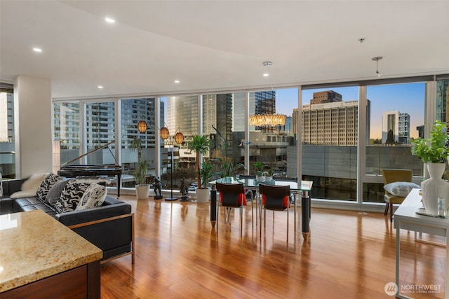 living room with floor to ceiling windows, a city view, wood finished floors, and a chandelier