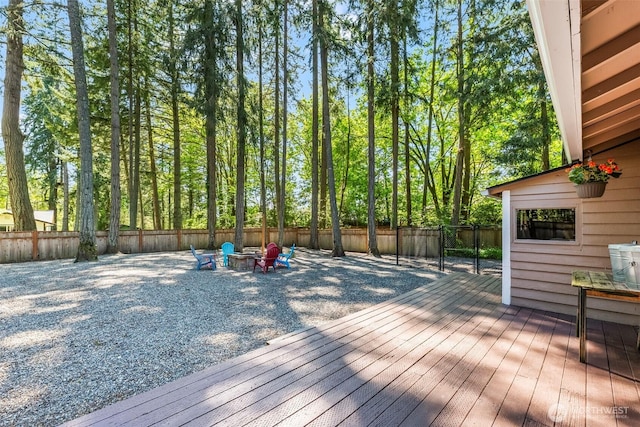 wooden terrace featuring a fire pit and a fenced backyard