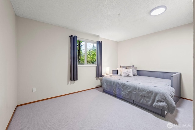 carpeted bedroom featuring baseboards and a textured ceiling