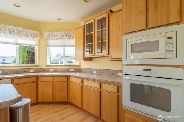 1701 E Burr Ave Unit 12, Moses Lake, WA 98837 - kitchen featuring white appliances, light wood-style flooring, glass insert cabinets, recessed lighting, and light countertops