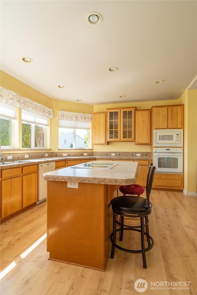 1701 E Burr Ave Unit 12, Moses Lake, WA 98837 - kitchen featuring white appliances, a center island, plenty of natural light, glass insert cabinets, and recessed lighting