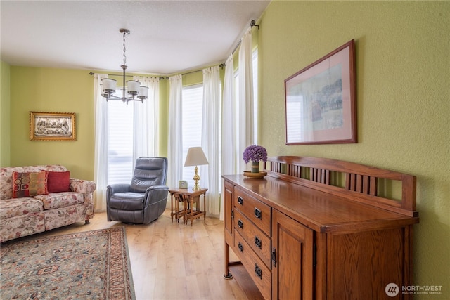1701 E Burr Ave Unit 12, Moses Lake, WA 98837 - sitting room featuring light wood-style flooring, a chandelier, and a textured wall