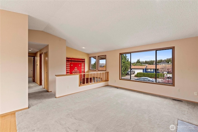 920 11th St NE, East Wenatchee, WA 98802 - unfurnished living room featuring vaulted ceiling, carpet floors, and baseboards