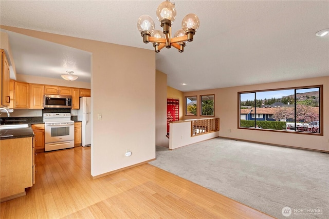 920 11th St NE, East Wenatchee, WA 98802 - kitchen featuring white appliances, a sink, open floor plan, a chandelier, and dark countertops
