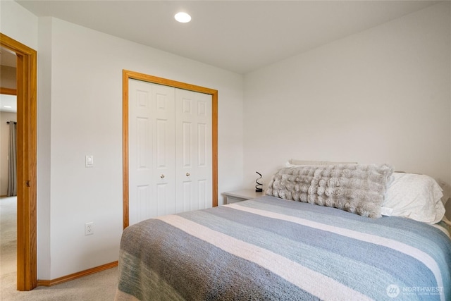 bedroom with baseboards, recessed lighting, a closet, and light colored carpet