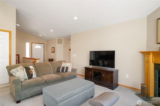 living area featuring a fireplace, vaulted ceiling, visible vents, and light carpet