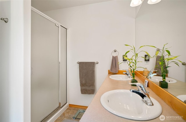 full bath featuring a sink, double vanity, and a stall shower