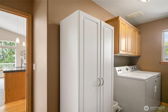 laundry room with cabinet space, a sink, and separate washer and dryer