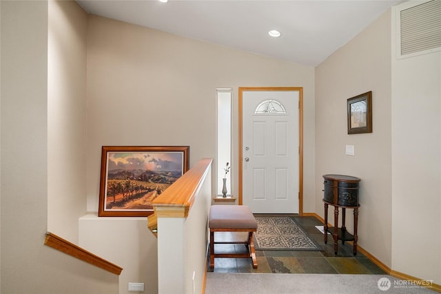 foyer entrance featuring baseboards, visible vents, recessed lighting, lofted ceiling, and stone finish flooring