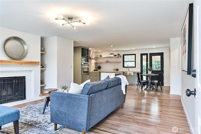 living area featuring light wood finished floors, a fireplace, and baseboards