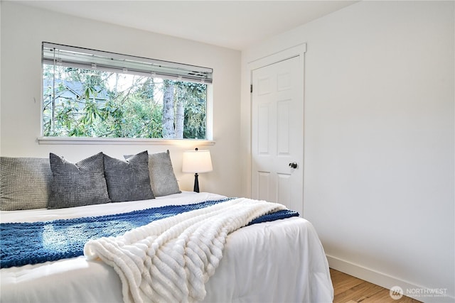 bedroom featuring wood finished floors and baseboards