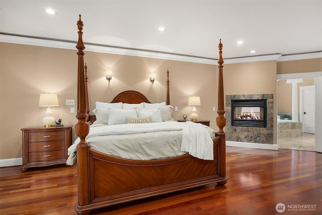 bedroom with crown molding, wood finished floors, and a premium fireplace