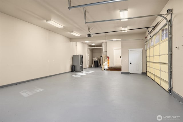 garage with baseboards, a garage door opener, and freestanding refrigerator