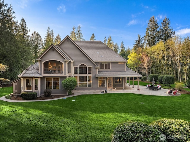 back of property featuring a patio area, a lawn, and a balcony