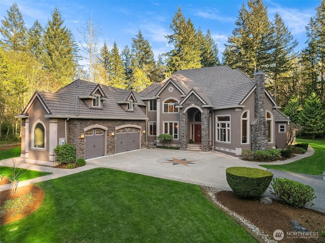view of front of home featuring stone siding, concrete driveway, and stucco siding