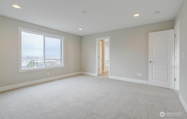unfurnished room with baseboards, recessed lighting, and light carpet