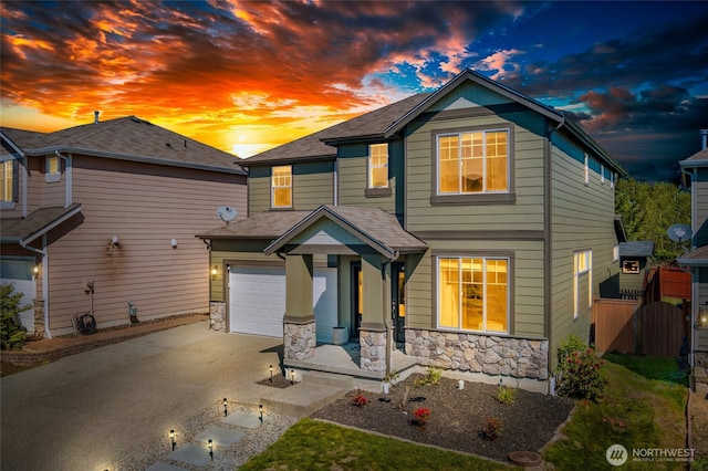 view of front of house with fence, driveway, stone siding, roof with shingles, and a garage