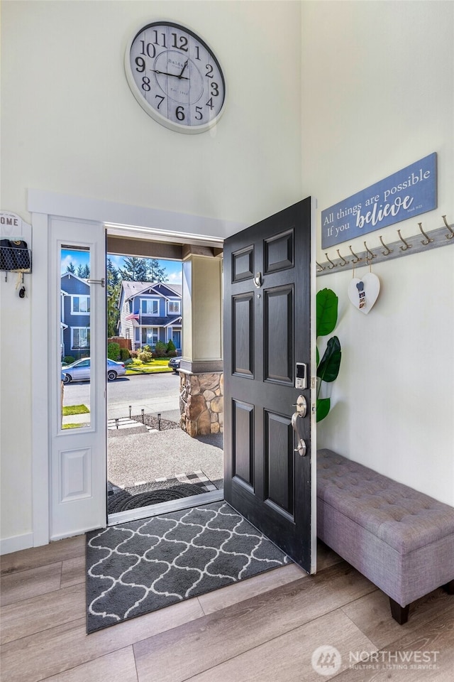 entryway featuring a high ceiling, wood finished floors, and baseboards
