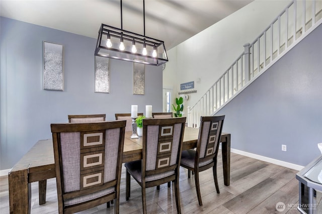 dining area featuring stairs, wood finished floors, and baseboards