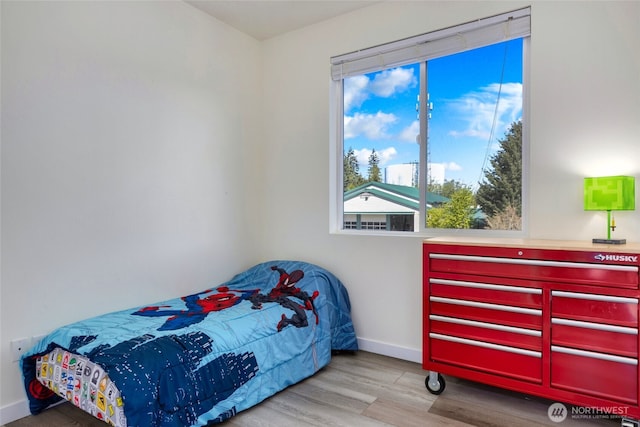 bedroom with baseboards and wood finished floors