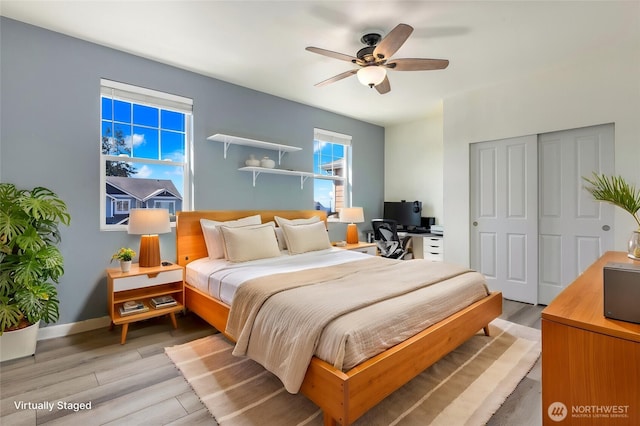 bedroom with light wood-style flooring, baseboards, a closet, and ceiling fan