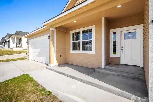 property entrance featuring driveway and a garage