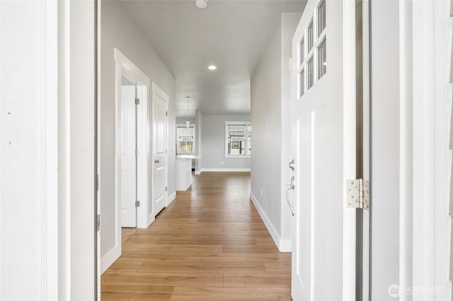 hall with baseboards, recessed lighting, and light wood-style flooring