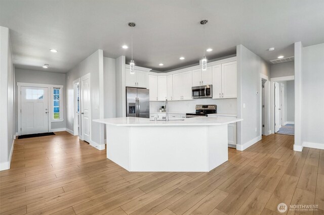 kitchen with a sink, light countertops, baseboards, and stainless steel appliances