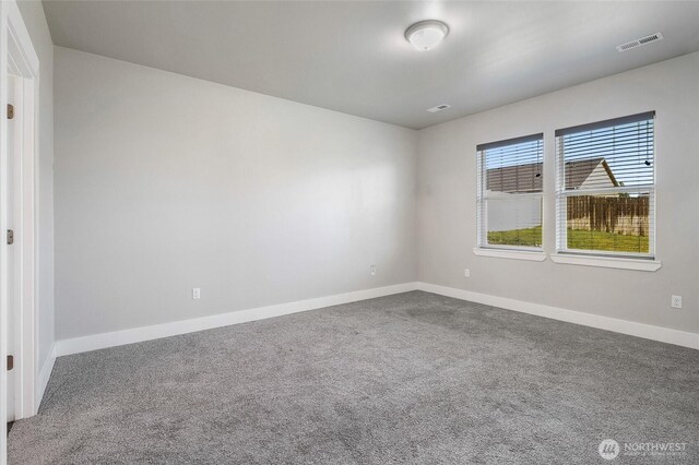 unfurnished room with carpet floors, baseboards, and visible vents