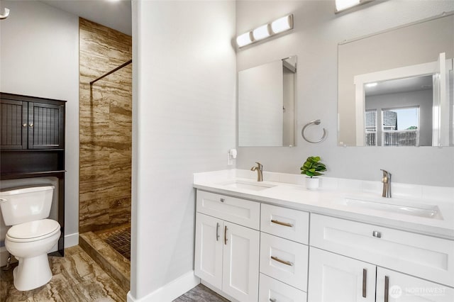 full bath featuring a sink, a stall shower, and toilet