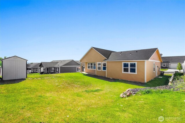 back of property featuring a lawn and an outdoor structure