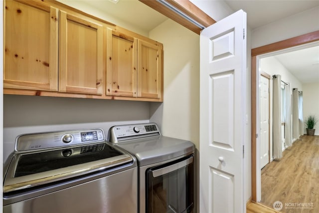 laundry area with washer and dryer, cabinet space, and light wood-type flooring