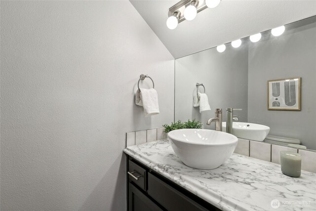 bathroom with lofted ceiling and vanity