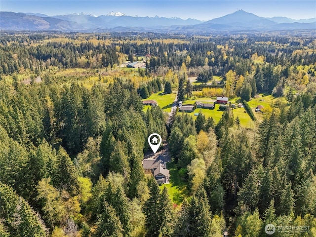 drone / aerial view featuring a view of trees and a mountain view