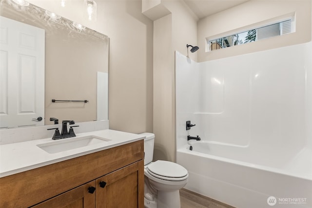 full bathroom featuring wood finished floors, toilet, shower / washtub combination, and vanity